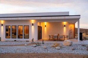 Une maison moderne dotée d’un patio, d’un espace salon extérieur et d’une piscine.