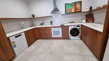 A compact kitchen with a dishwasher, oven, and washing machine.