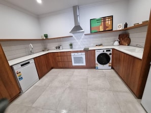 A compact kitchen with a dishwasher, oven, and washing machine.
