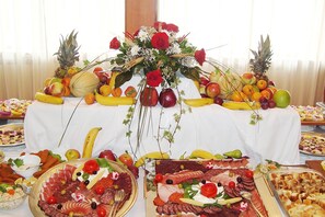 Una mesa de buffet con diferentes tipos de comida y un centro de mesa con flores.