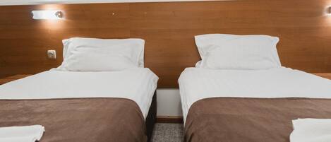 A double bed room with a wooden headboard and two white pillows.
