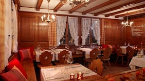 A restaurant with wooden paneling, chandeliers, and tables set for dining. - Landgasthof Hotel Rv Ssli (Adligenswil)