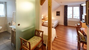 A room with a bed, a desk, a chair, a radiator, and a window with curtains. - Landgasthof Hotel Rv Ssli (Adligenswil)