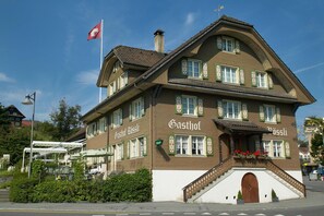Un bâtiment à deux étages sur lequel on peut lire l’inscription « Gasthof ».