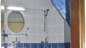 Un baño con lavamanos pedestal, inodoro y zona de ducha.