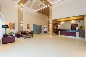 A spacious lobby with a reception desk, seating area, and a large window. - Hotel Olivia Medical Spa (Tokarnia)