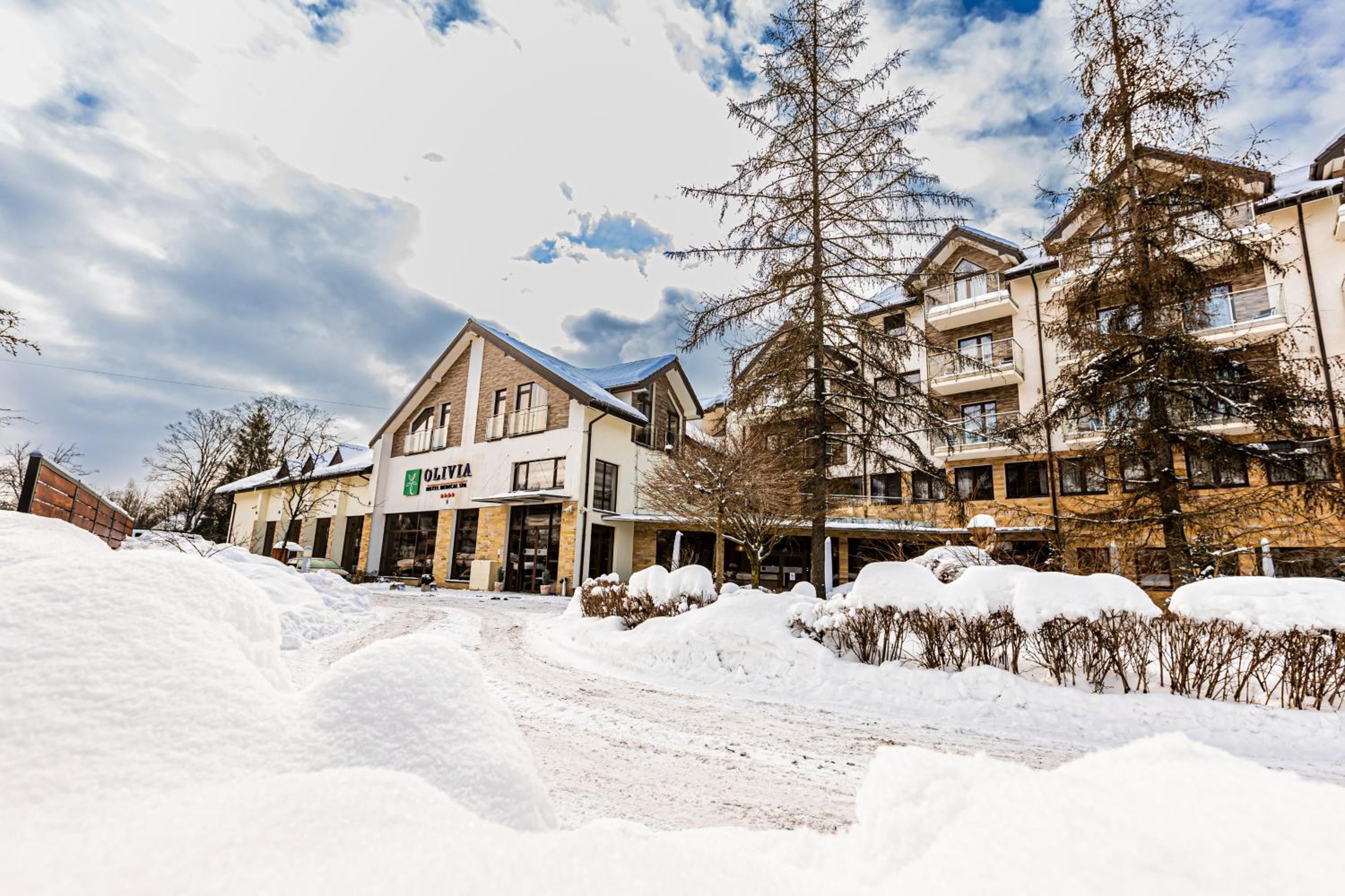 A hotel with a traditional architectural style, featuring a prominent entrance and a signboard.