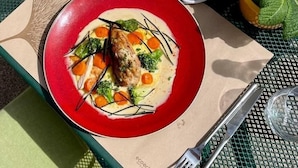 Ein Tisch ist gedeckt mit einem Teller mit Essen, einer Schüssel Brot und einer Speisekarte.