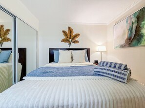 A hotel room with a bed, a nightstand, a lamp, and a painting on the wall. - Waterfront, 8 Min to TPA & 12 Min Raymond James (Tampa)