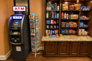 Ein Geldautomat, eine Snackbar mit verschiedenen Snacks und Getränken sowie eine Auswahl an Postkarten.