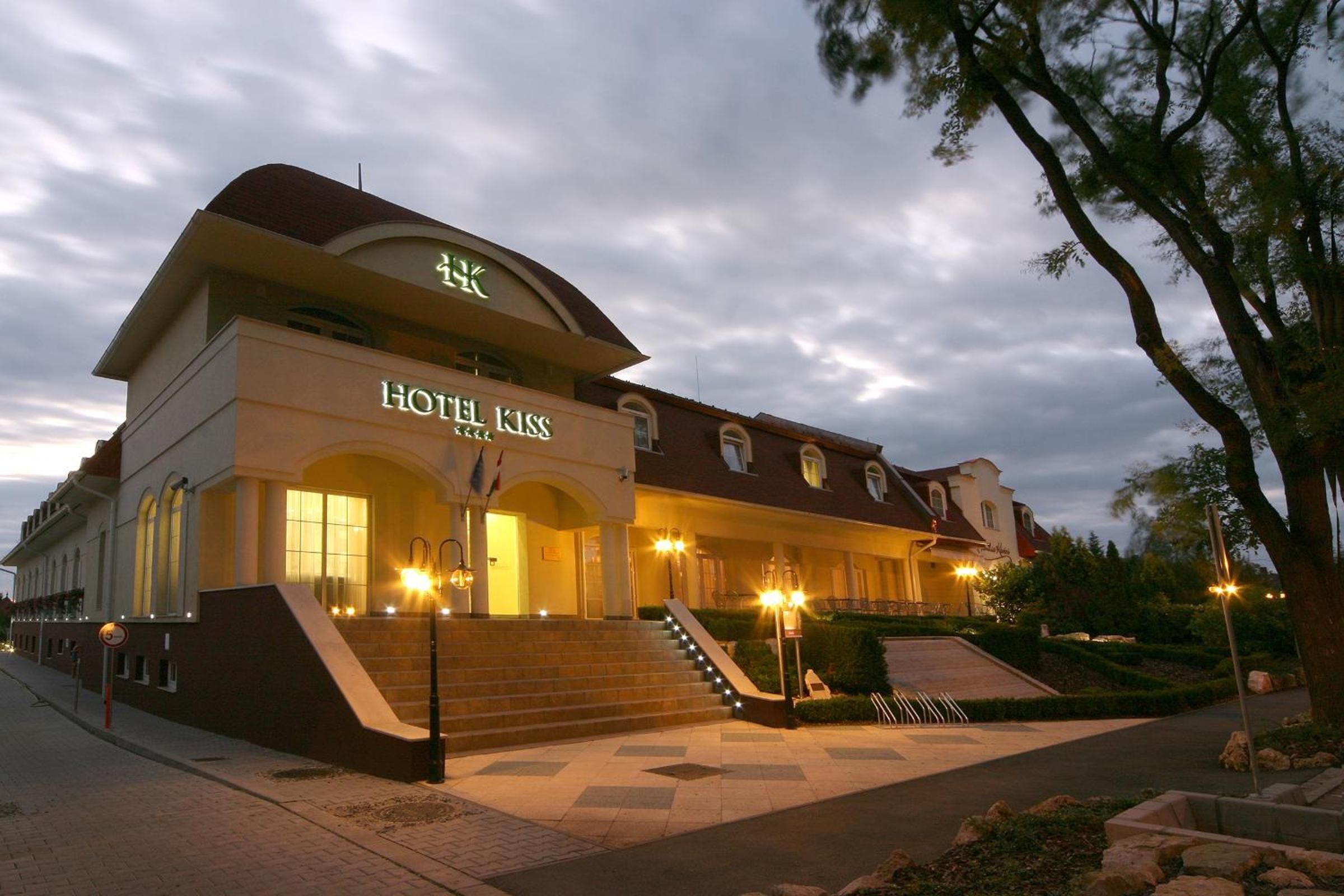 A hotel with a prominent entrance, a staircase leading to the main doors, and a well-lit facade.