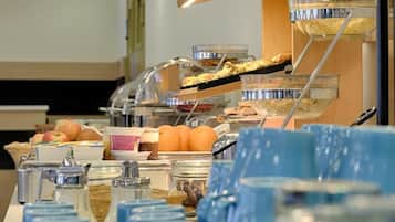 A buffet setup with various food items and a coffee station.