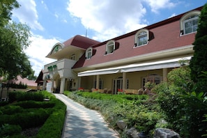 Un hotel con un patio central, una zona de estar cubierta al aire libre y un jardín bien cuidado.