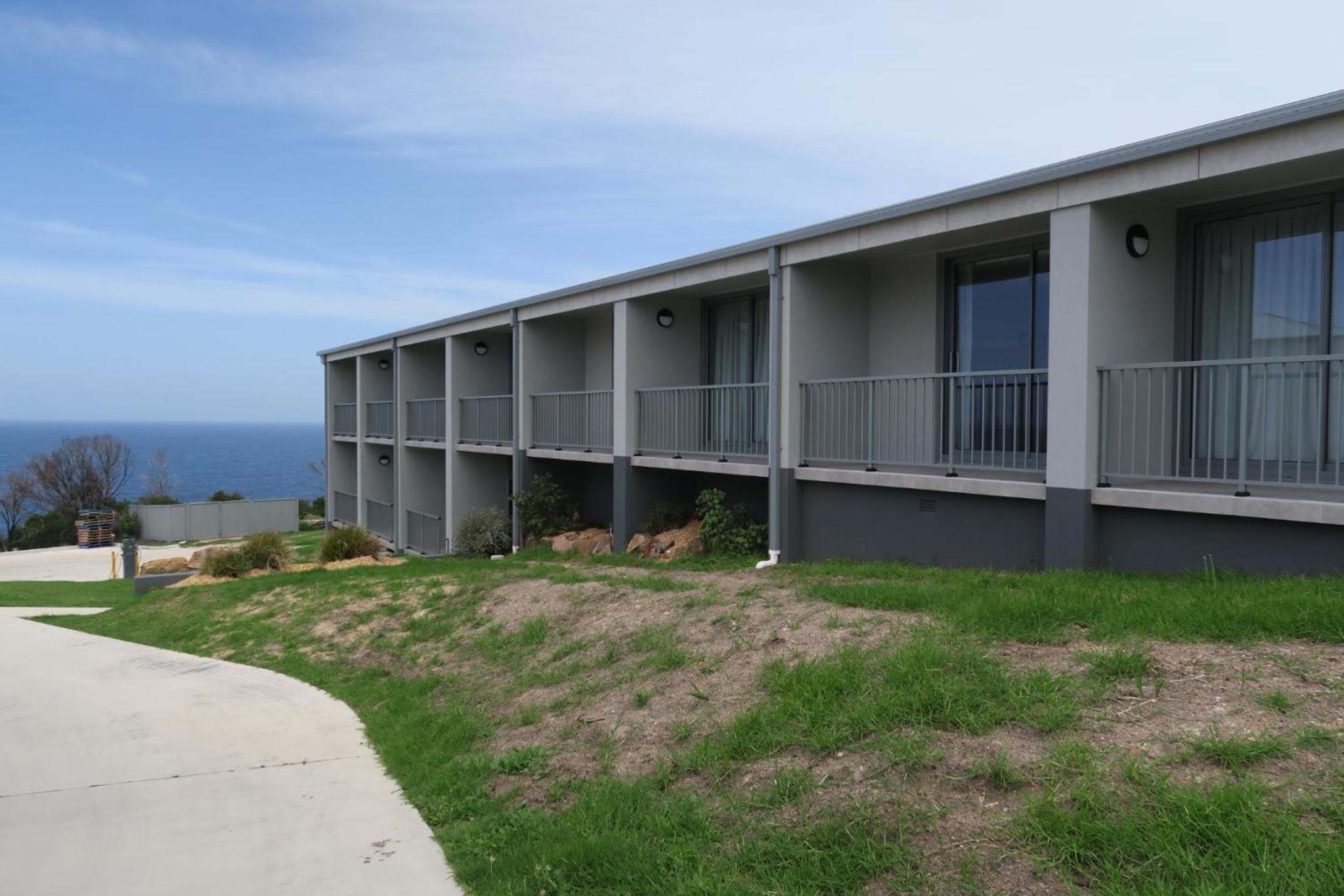 Un immeuble à plusieurs étages, doté de balcons et offrant une vue sur l’océan.
