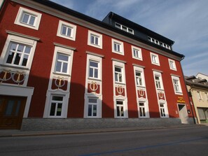 Een rood gebouw met witte raamkozijnen en een zwart dak.