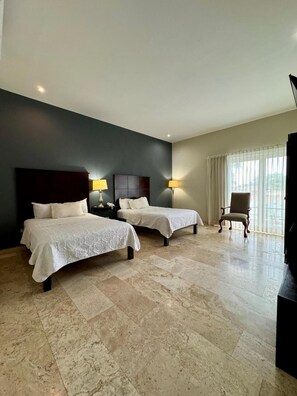 A hotel room with two beds, a chair, a desk, and a large window. - Grann Hotel (Ciudad Valles)