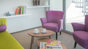 Uma sala de estar moderna com sofá, poltronas, mesa de centro e estante.