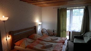 Ein Hotelzimmer mit einem Bett, zwei Wandlampen, einem Sessel, einem kleinen Tisch und einer Couch.