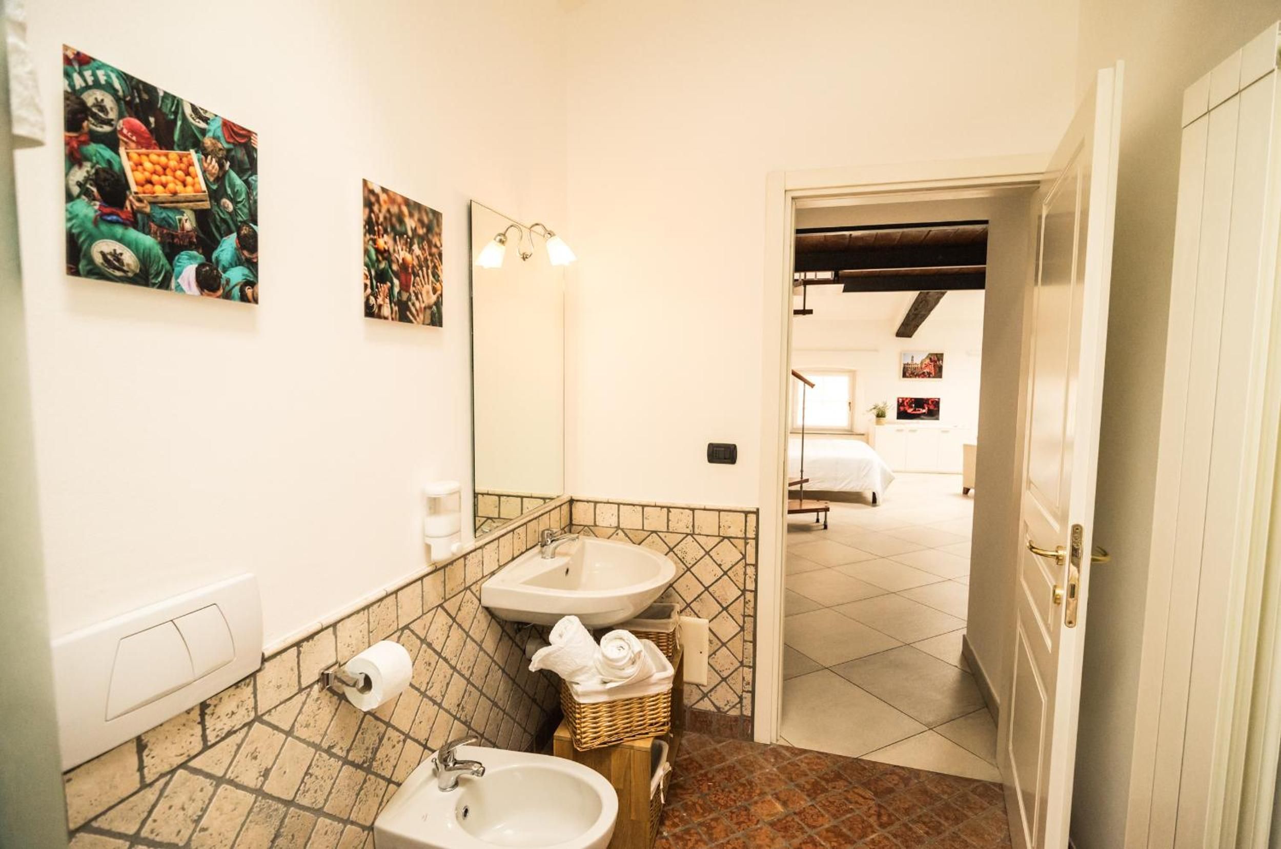 Ein Badezimmer mit zwei Waschbecken, einem Spiegel und einer Wandleuchte.