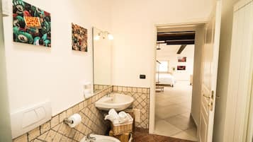 Une salle de bain avec deux lavabos, un miroir et un luminaire fixé au mur.