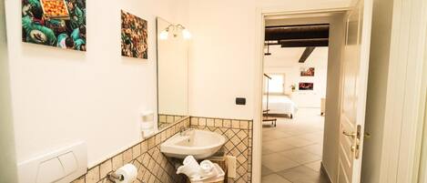 A bathroom with two sinks, a mirror, and a wall-mounted light fixture.