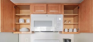 A kitchen with wooden cabinets, a microwave, and a coffee maker. - Blueground | Ballston, pool, nr Arlington Cemetery (Arlington)