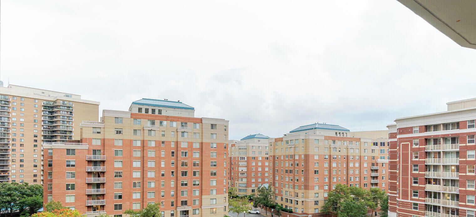 Un edificio residenziale a più piani con balconi, un tetto piatto e cielo sereno.