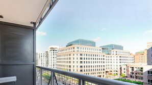 A balcony with a view of high-rise buildings, a metal railing, and a door. - Blueground | Ballston, pool, nr Arlington Park (Arlington)