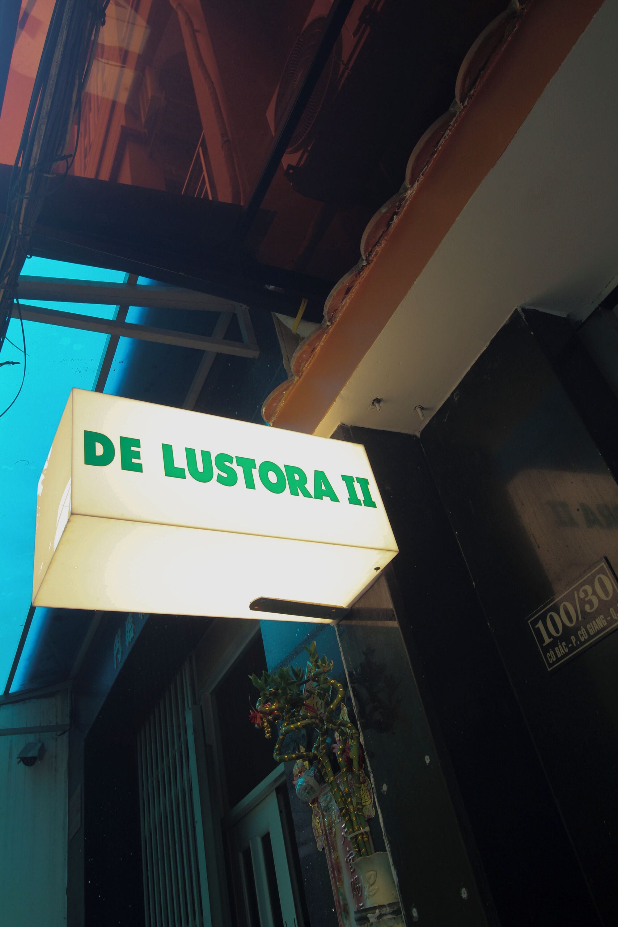 A sign with the text 'DE LUSTORA II' indicating a hotel or establishment.