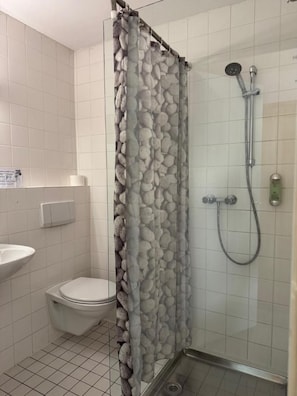 Un baño con ducha, inodoro y lavamanos.