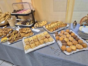 Una mesa de buffet con diversos productos horneados y pastelería.