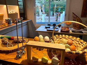Een keukentrap met verschillende keukengerei, een mand met eieren, en een houten bordje met kooktijden.