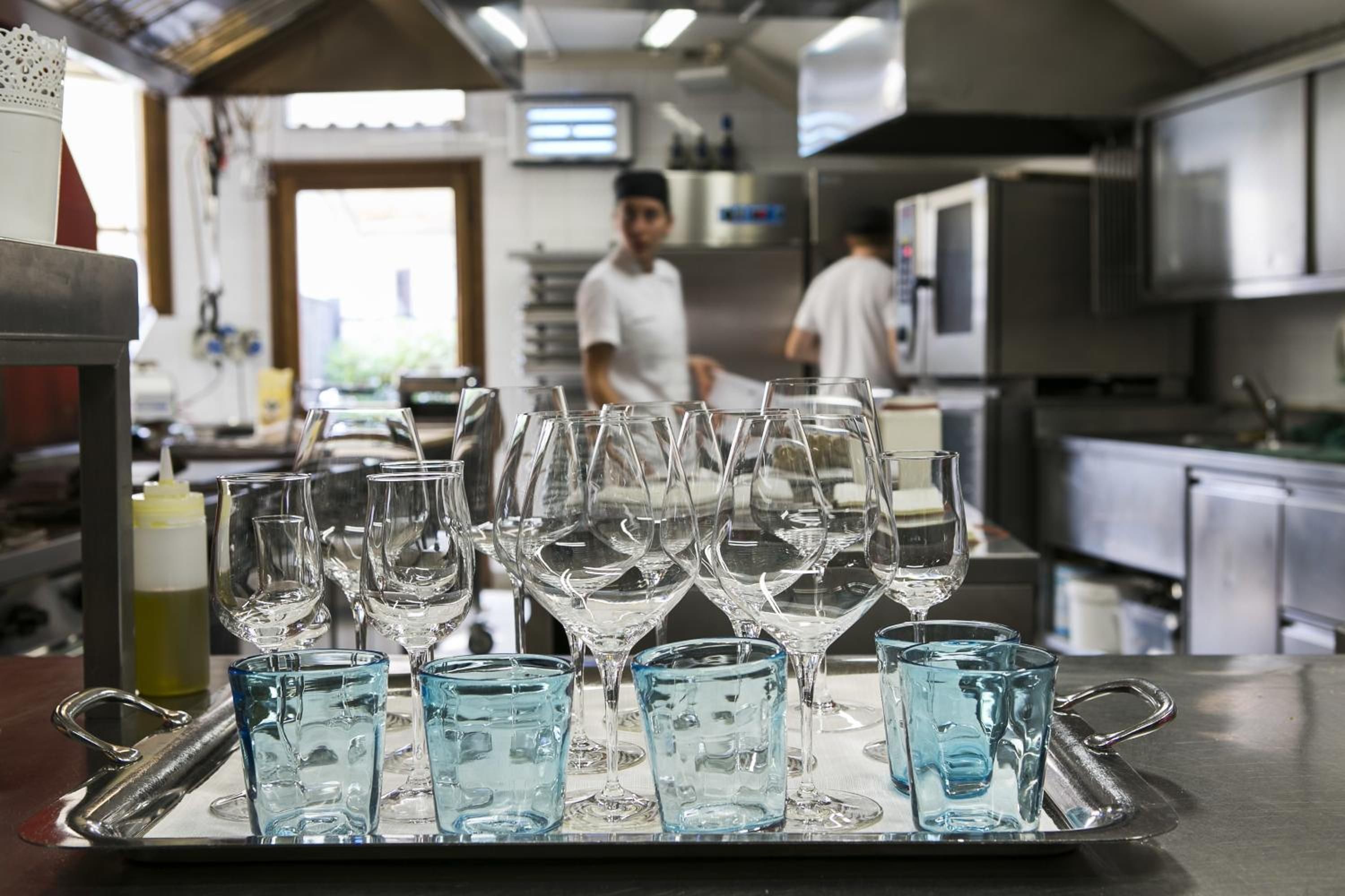 Una cocina con electrodomésticos de acero inoxidable y una bandeja de vasos vacíos.