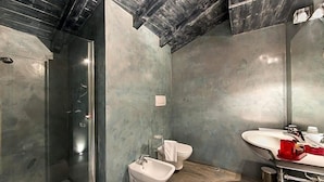 Un baño moderno con ducha a nivel, un bidé y un tocador con espejo.