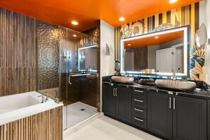 Un baño moderno con un espejo grande, una bañera y una ducha a ras de suelo.
