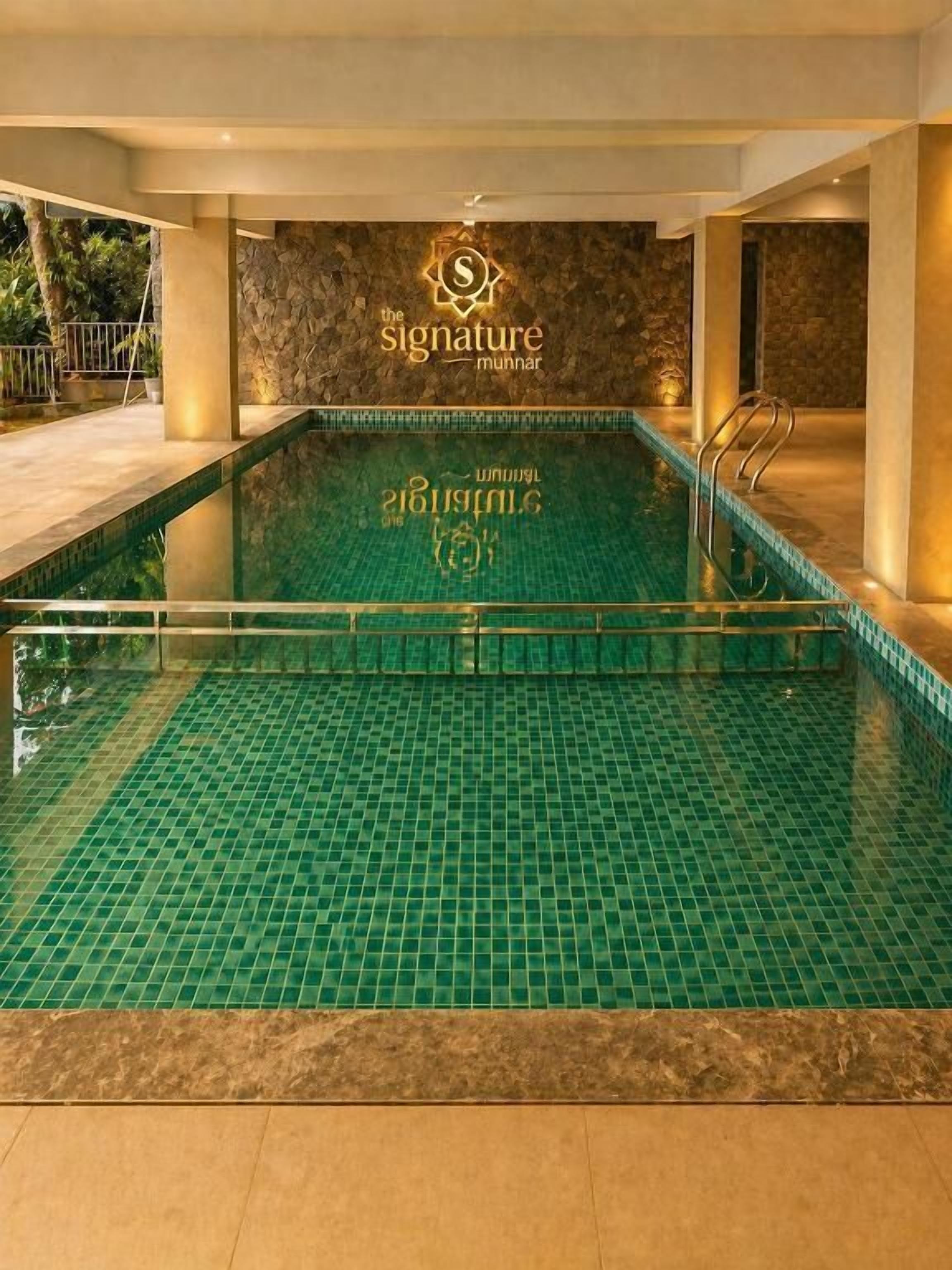 Una piscina interior con suelo de baldosas y un logotipo en la pared.