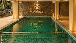 Una piscina interior con suelo de baldosas y un logotipo en la pared.