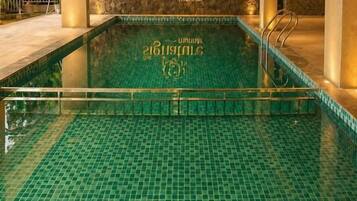 Una piscina interior con suelo de baldosas y un logotipo en la pared.