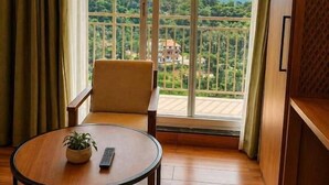 Una habitación con balcón, una mesa redonda y una silla.