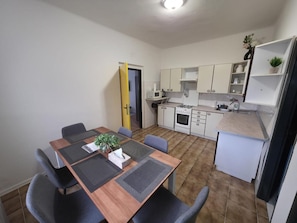 A compact kitchen with a dining area, a microwave, a stove, and a sink.