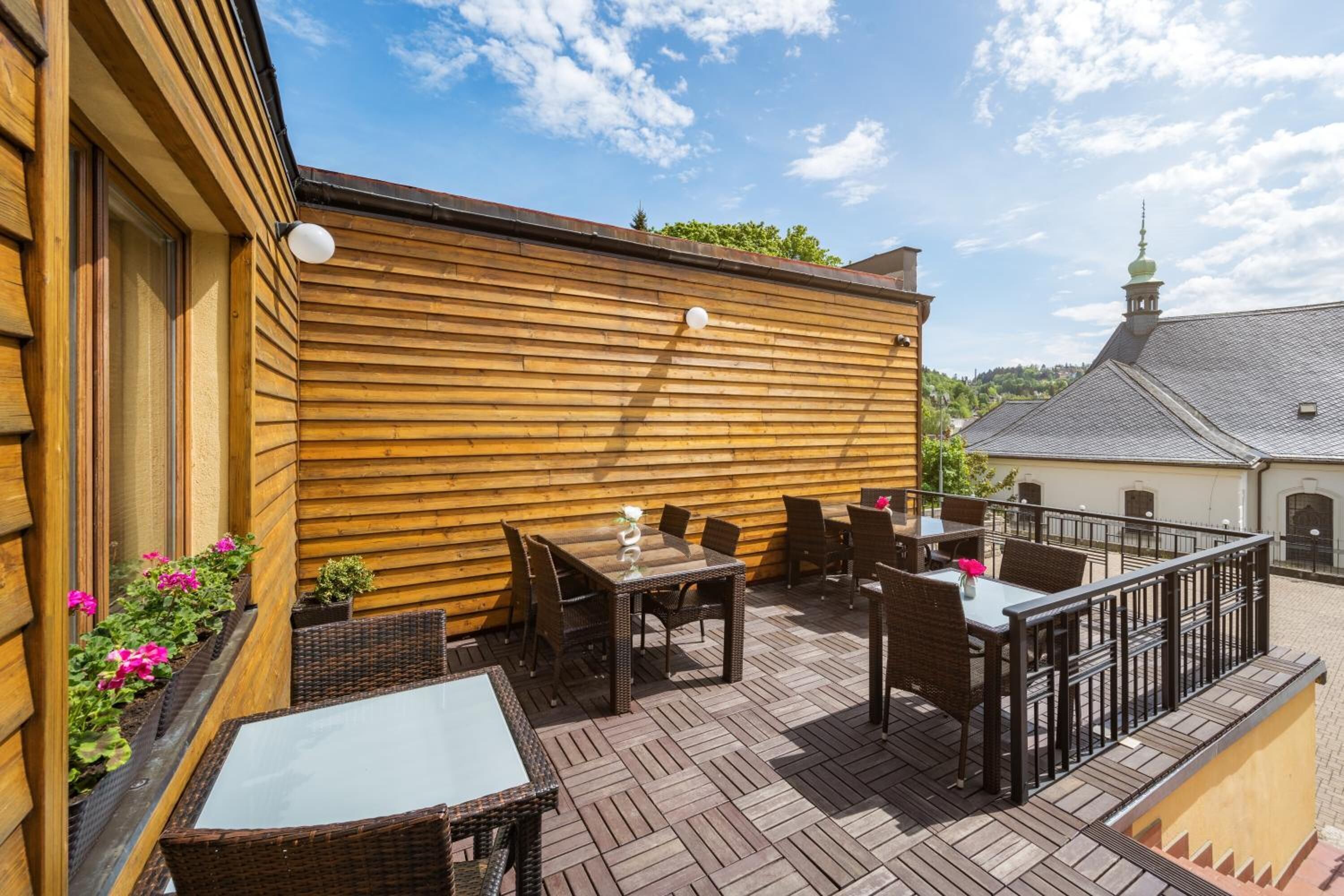 An outdoor patio with wooden walls, wicker furniture, and a brick floor.