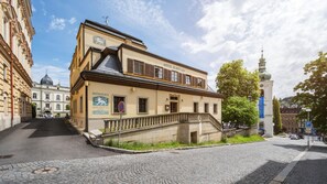 Un edificio con un letrero que dice 'HOTEL ZLATÝ LEV' y una escalera que lleva a la entrada.