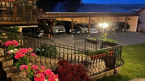 Una estructura de estacionamiento de varios niveles con varios autos estacionados, rodeada por un jardín ajardinado con diversas flores.