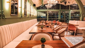 Un restaurant doté d’un long banc servant de siège, de tables et de chaises en bois.
