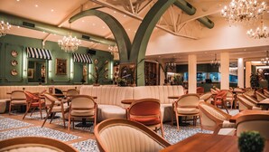 Un vaste espace salon doté d’un haut plafond, de plusieurs coins salon et d’un éclairage décoratif.