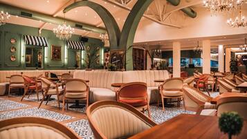Ein großzügiger Lounge-Bereich mit hoher Decke, verschiedenen Sitzgelegenheiten und dekorativer Beleuchtung.