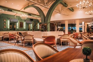Ein großzügiger Lounge-Bereich mit hoher Decke, verschiedenen Sitzgelegenheiten und dekorativer Beleuchtung.