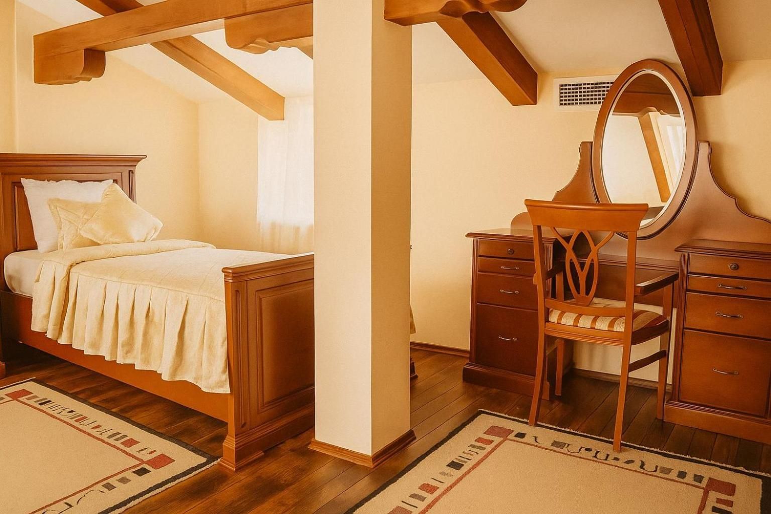 Une chambre à coucher avec un lit en bois, une commode, une chaise et un miroir.
