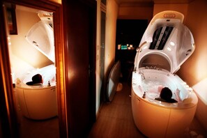 Un cuarto de spa con dos jacuzzis, piso de madera y un espejo que refleja el ambiente.