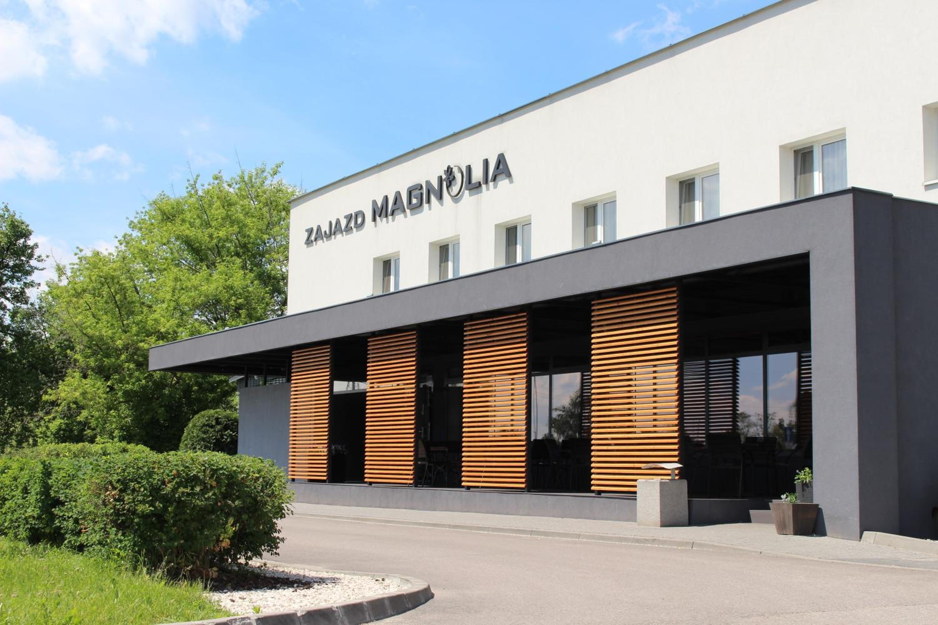 Un edificio moderno con un letrero que dice 'ZAJAZD MAGNOLIA'.
